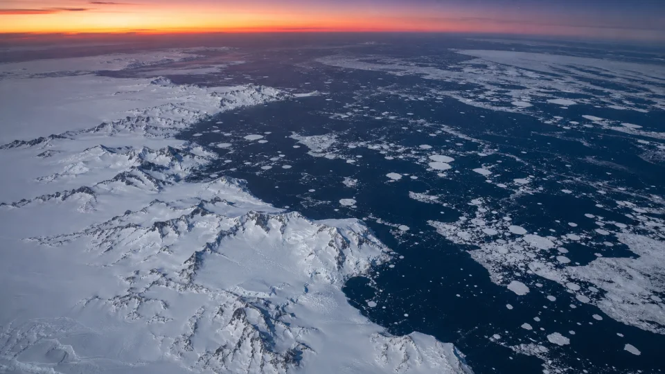 Open water in the Bellingshausen Sea off West Antarctica during austral winter, with broken sea ice and the Antarctic Peninsula under polar twilight