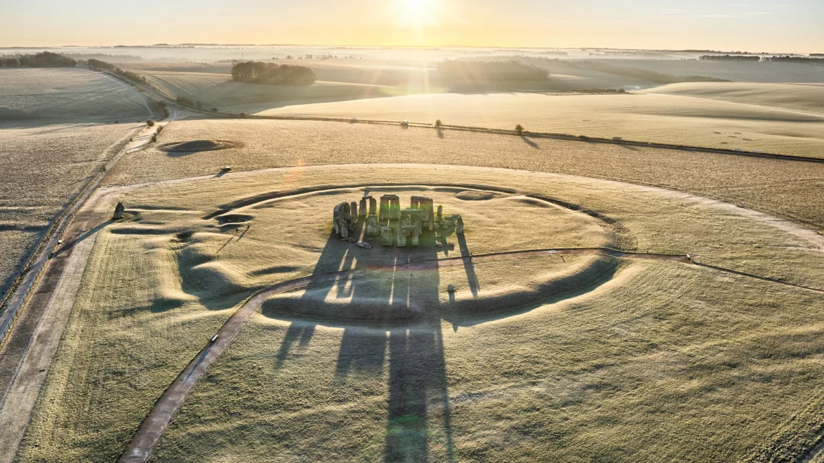 Stonehenge at dawn on Salisbury Plain, with the rising sun casting long shadows across the stone circle — Chris Gorman / Getty Images