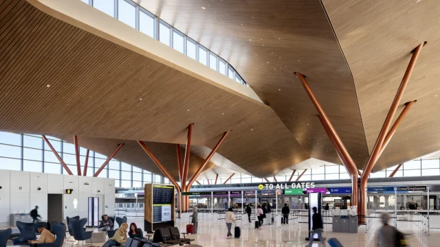Faceted wood ceiling and tree-shaped copper columns in the landside hall at Pittsburgh International Airport